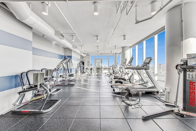 workout area featuring expansive windows and a textured ceiling