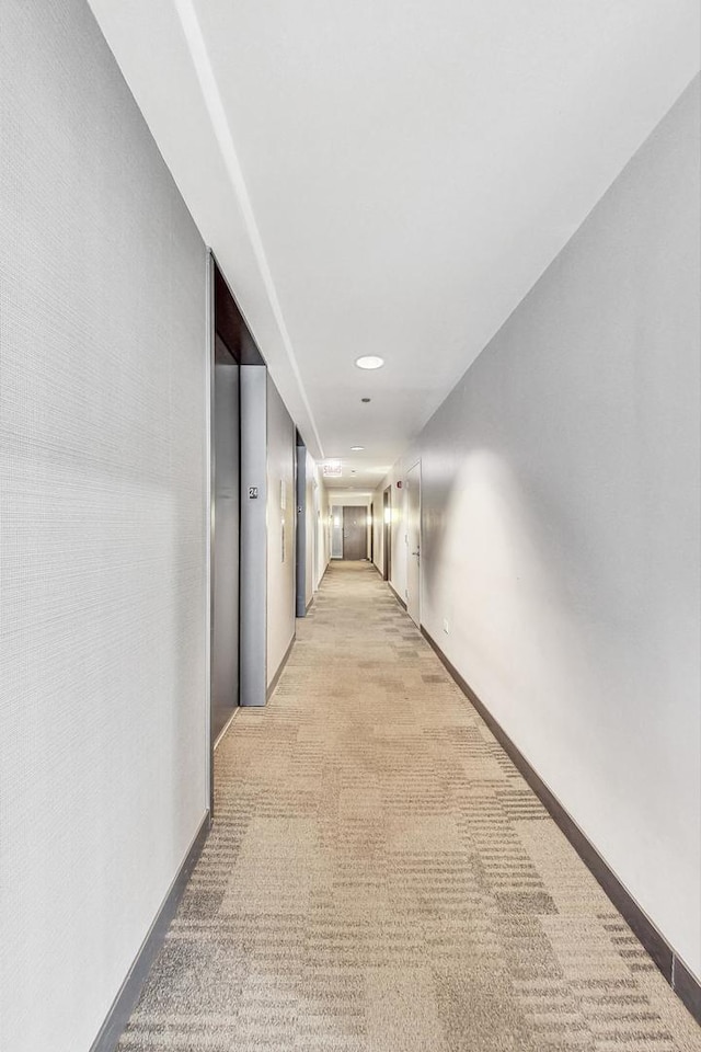 hall featuring light colored carpet