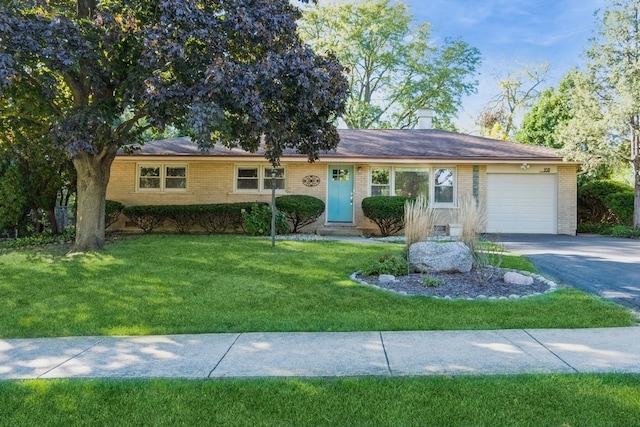 ranch-style house featuring a front yard and a garage