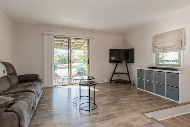 living room with hardwood / wood-style floors and crown molding