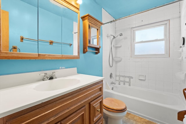 full bathroom featuring tile patterned flooring, tiled shower / bath combo, vanity, and toilet