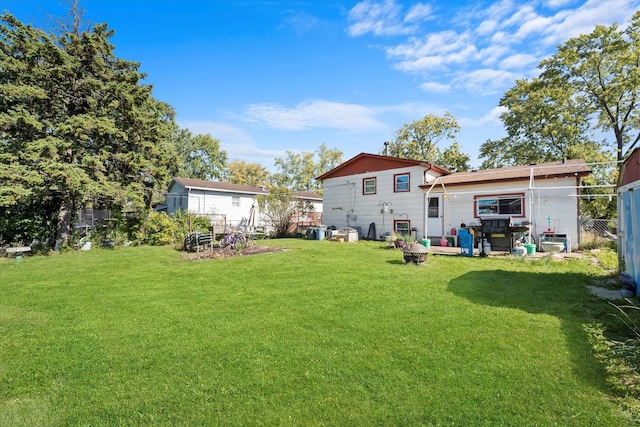 rear view of property with fence and a lawn