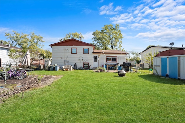 rear view of property with a shed, a patio, and a lawn