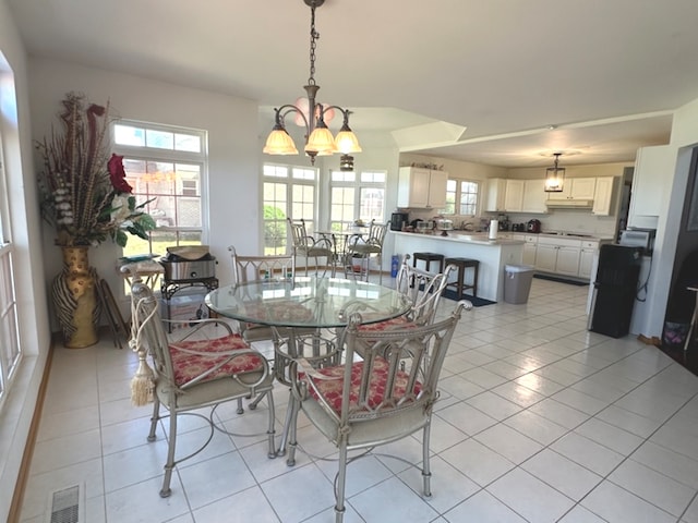 tiled dining space with an inviting chandelier