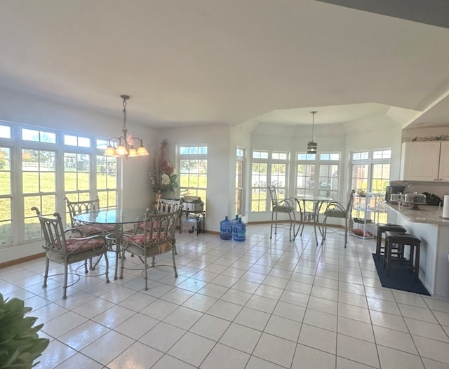 tiled dining space featuring a chandelier and a wealth of natural light