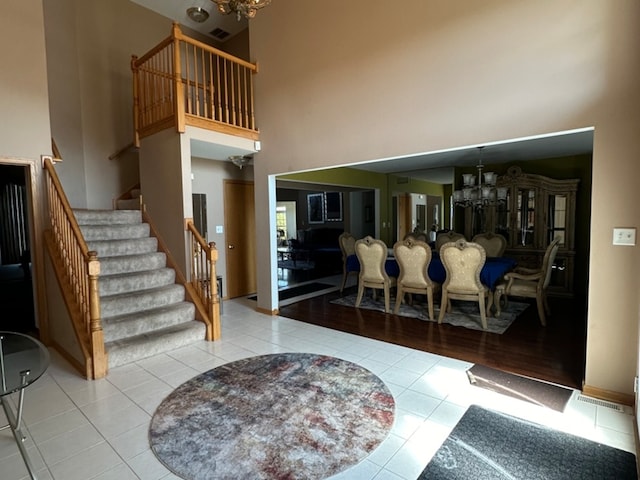 foyer with a high ceiling, an inviting chandelier, and light tile patterned floors