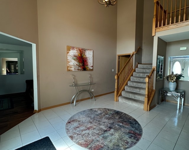 entryway with a towering ceiling and light tile patterned floors