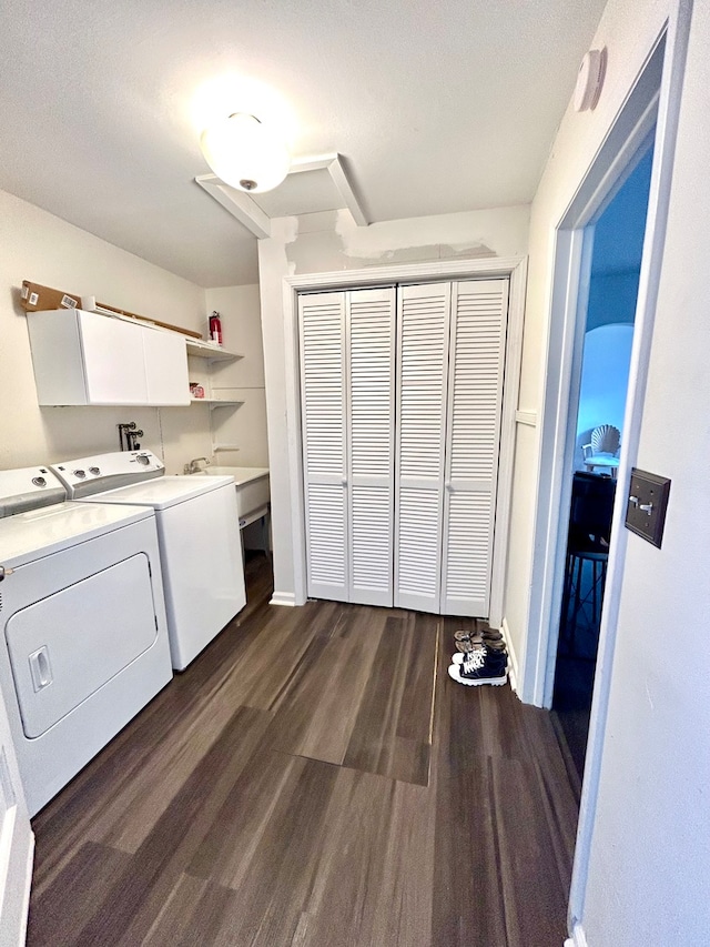 laundry area featuring a textured ceiling, dark hardwood / wood-style flooring, independent washer and dryer, and cabinets