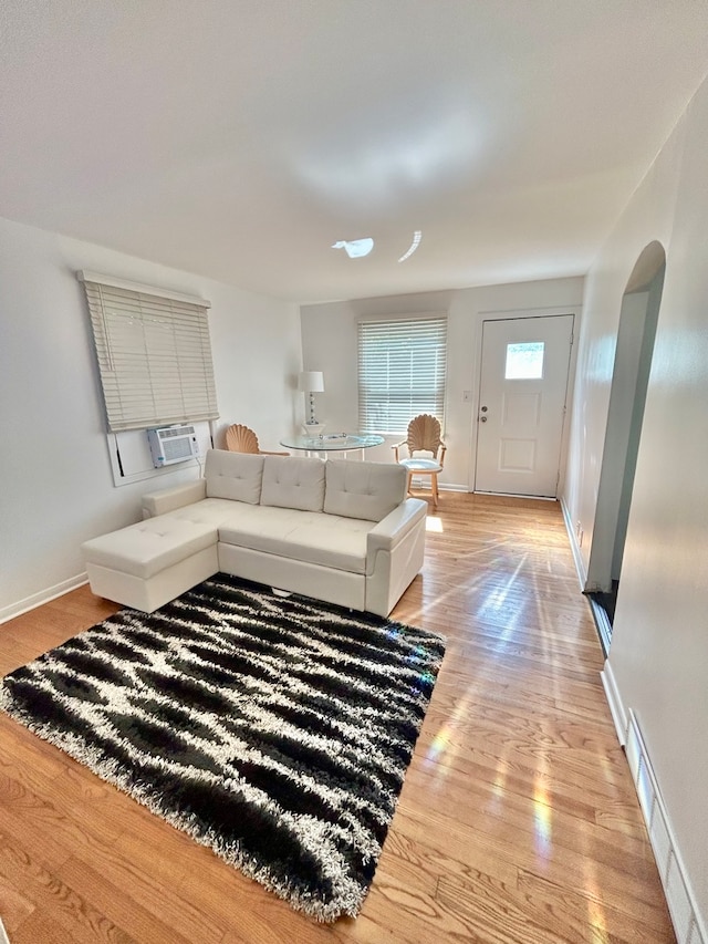 living room featuring cooling unit and light hardwood / wood-style flooring