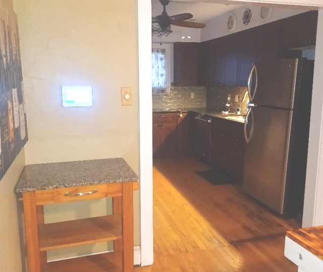 kitchen featuring ceiling fan, stainless steel fridge, light hardwood / wood-style floors, and tasteful backsplash