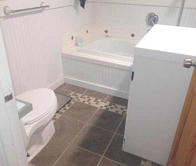 bathroom with toilet, vanity, tiled bath, and tile patterned floors