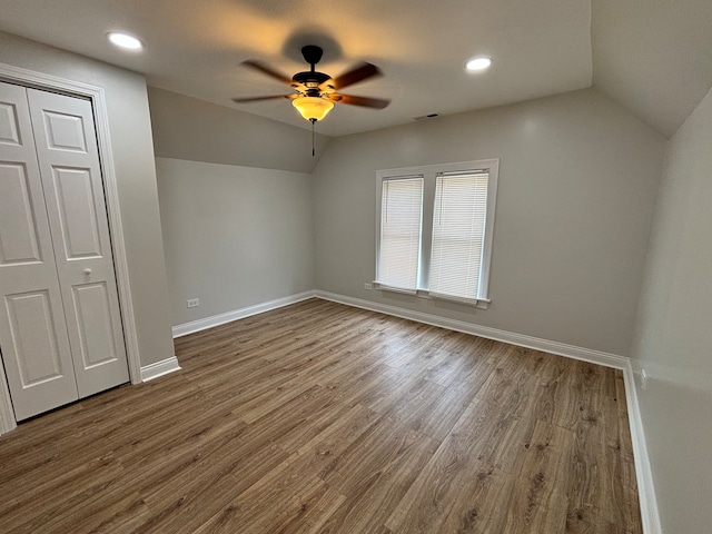 unfurnished bedroom featuring a closet, vaulted ceiling, ceiling fan, and hardwood / wood-style floors