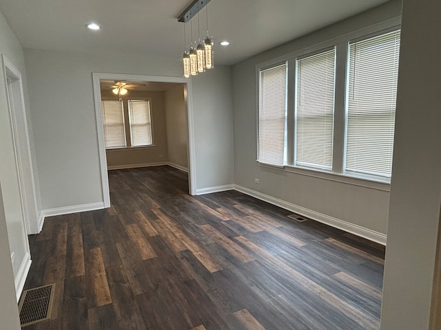 unfurnished dining area with ceiling fan and dark hardwood / wood-style floors