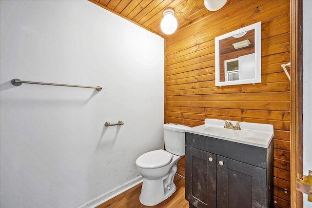 bathroom with vanity, toilet, wood walls, wooden ceiling, and hardwood / wood-style floors