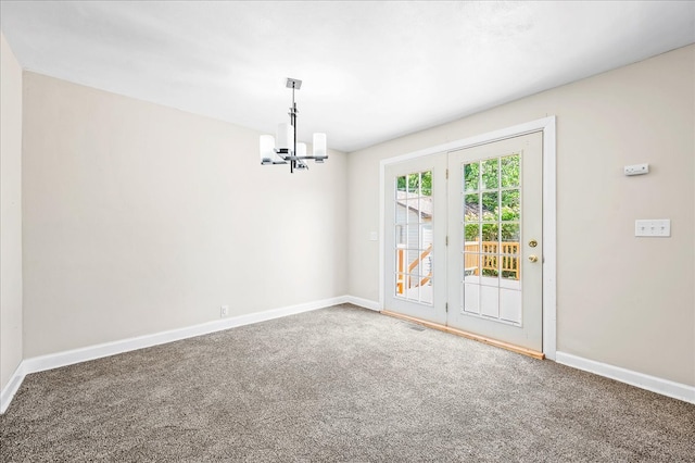 unfurnished room with a chandelier and carpet