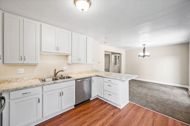 kitchen with appliances with stainless steel finishes, white cabinetry, kitchen peninsula, hardwood / wood-style floors, and sink