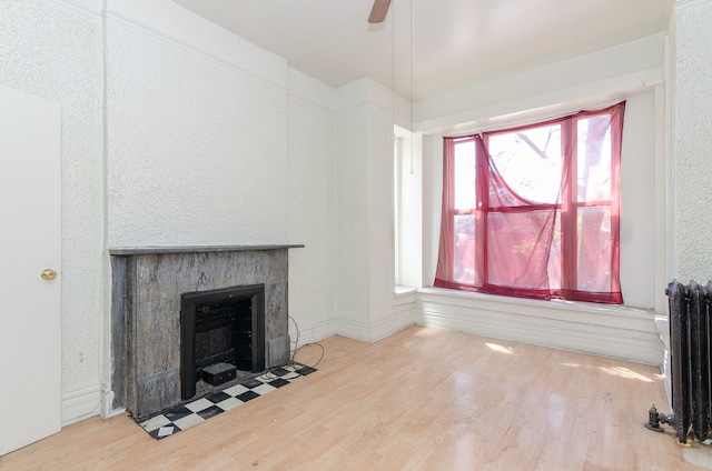 living room with ceiling fan, radiator, hardwood / wood-style floors, and a tile fireplace