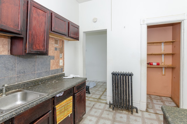 kitchen with radiator, backsplash, and sink