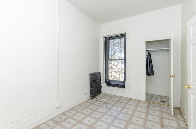 unfurnished bedroom featuring a closet and radiator heating unit