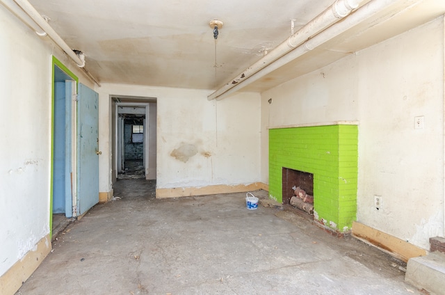 interior space featuring concrete flooring and a brick fireplace