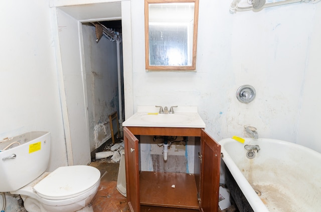 bathroom featuring toilet, vanity, and a tub