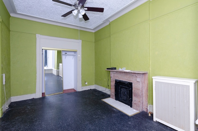 unfurnished living room with radiator heating unit, ceiling fan, a textured ceiling, and ornamental molding