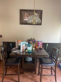 tiled dining area featuring a chandelier