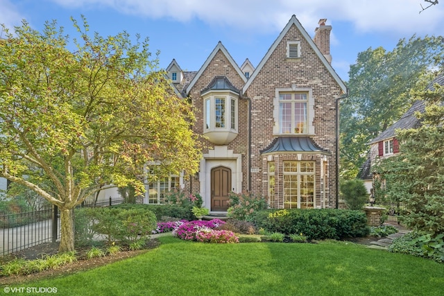 tudor-style house featuring a front lawn