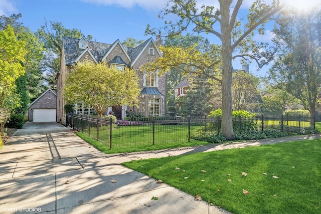 view of front of home featuring a garage, an outbuilding, and a front lawn