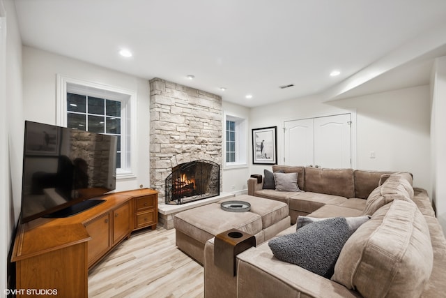 living room with light wood-type flooring and a fireplace