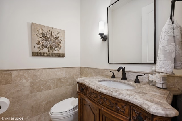 bathroom featuring tile walls, vanity, and toilet