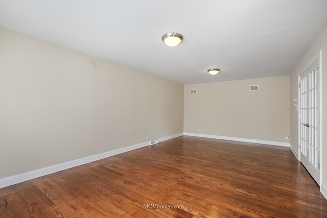 spare room with french doors and dark wood-type flooring