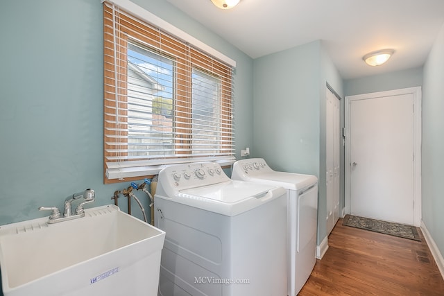 laundry room featuring hardwood / wood-style floors, separate washer and dryer, and sink