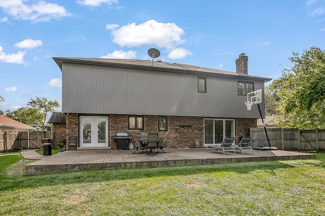 rear view of property featuring french doors, a lawn, and a patio