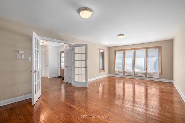 spare room featuring hardwood / wood-style floors and french doors