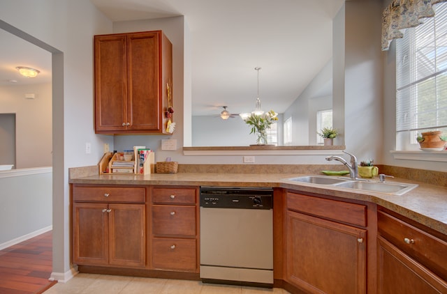 kitchen with white dishwasher, light wood-type flooring, sink, and a wealth of natural light