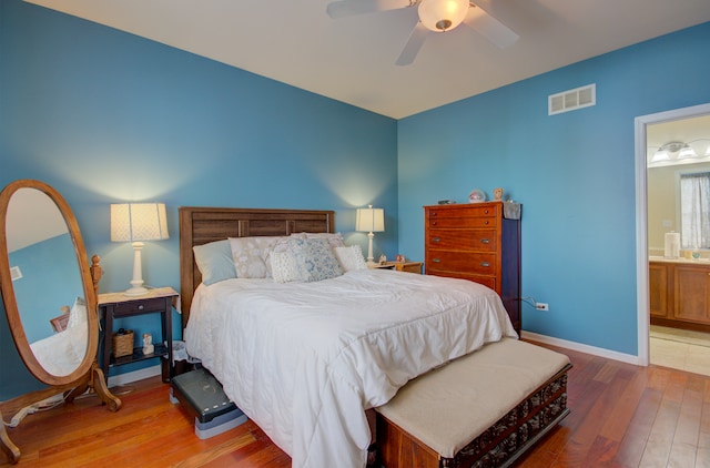 bedroom featuring wood-type flooring, ceiling fan, and connected bathroom