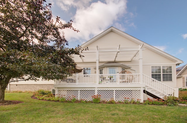 back of house featuring a wooden deck and a lawn