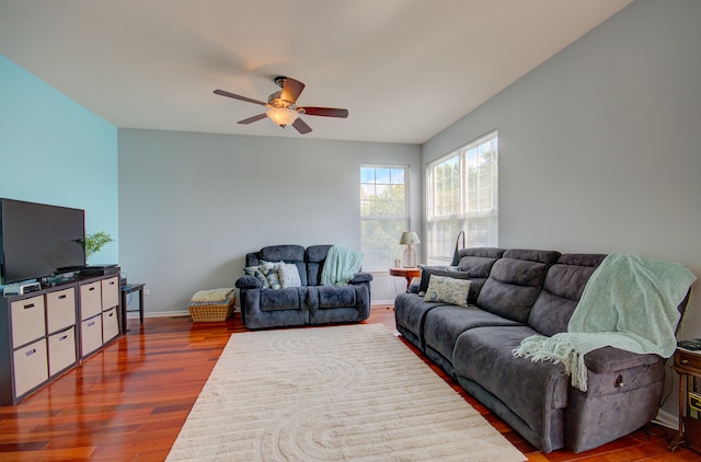 living room with ceiling fan and dark hardwood / wood-style flooring