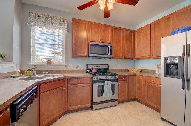 kitchen featuring ceiling fan, stainless steel appliances, and sink