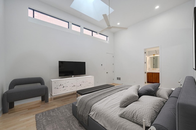 bedroom featuring light wood-type flooring, a skylight, multiple windows, and recessed lighting