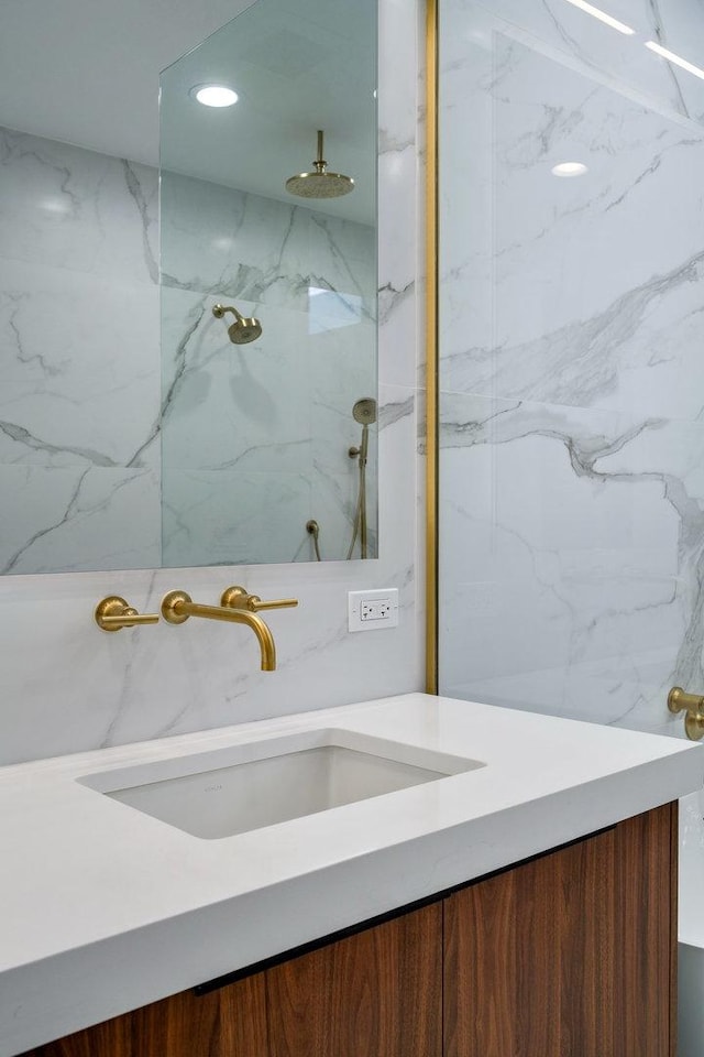 full bathroom featuring vanity and a marble finish shower