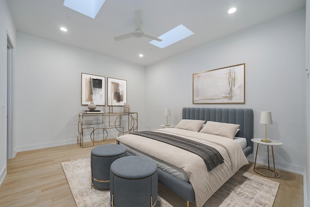 bedroom with a skylight, light wood-style flooring, and recessed lighting