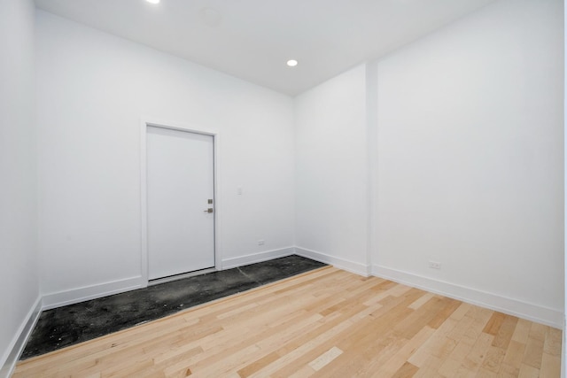 empty room with baseboards, wood finished floors, and recessed lighting