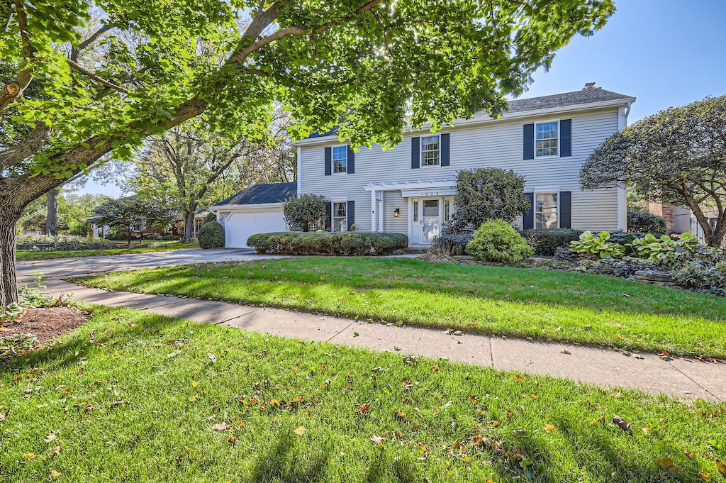 colonial house with a front yard and a garage