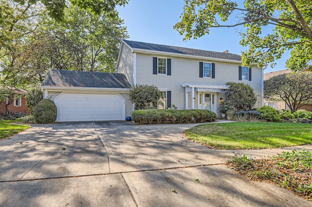 colonial house featuring a front yard and a garage