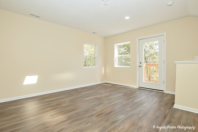 spare room with vaulted ceiling, hardwood / wood-style floors, and a wealth of natural light