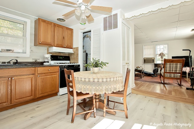 kitchen with cooling unit, sink, white gas stove, light wood-type flooring, and decorative backsplash