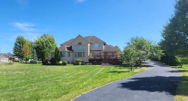 view of front of home featuring a front lawn and a deck