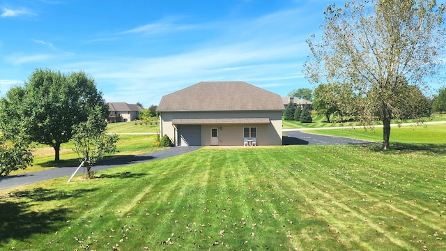 back of property with a lawn and a garage